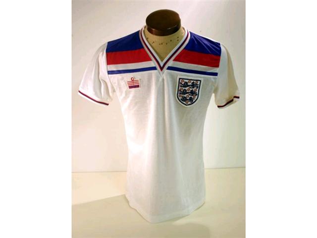 317. England International Shirt: A white with red & blue V-neck shirt with embroidered 3 Lions badge to front, No. 6 to rear also official Itinerary & programme. (3). £250-300 317. England International Shirt: A white with red & blue V-neck shirt with embroidered 3 Lions badge to front, No. 6 to rear also official Itinerary & programme. (3). £250-300