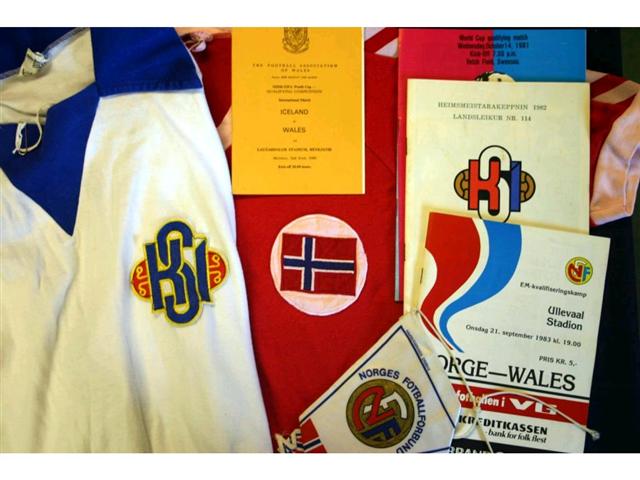 321. International Shirts Etc: A white with blue trim Iceland International Shirt with embroidered badge to front, No. 7 to rear plus itinerary, pin badge, programmes & ceramic tankard relating the match against Wales played in Reykjavik 2nd June 1980 (Giles scored in this match); also a red with white trim V-neck Norway shirt with embroidered badge to front, No.7 to rear plus programme & pennant relating to the match played in Oslo 21st September 1983. &pound;120-150 