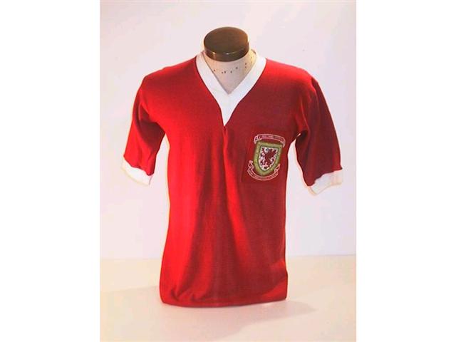 457. Wales International Shirt: A red with white trim V-neck shirt with embroidered Welsh crest to front with the match details above, No. 10 to rear. Illus. £500-700 457. Wales International Shirt: A red with white trim V-neck shirt with embroidered Welsh crest to front with the match details above, No. 10 to rear. Illus. £500-700